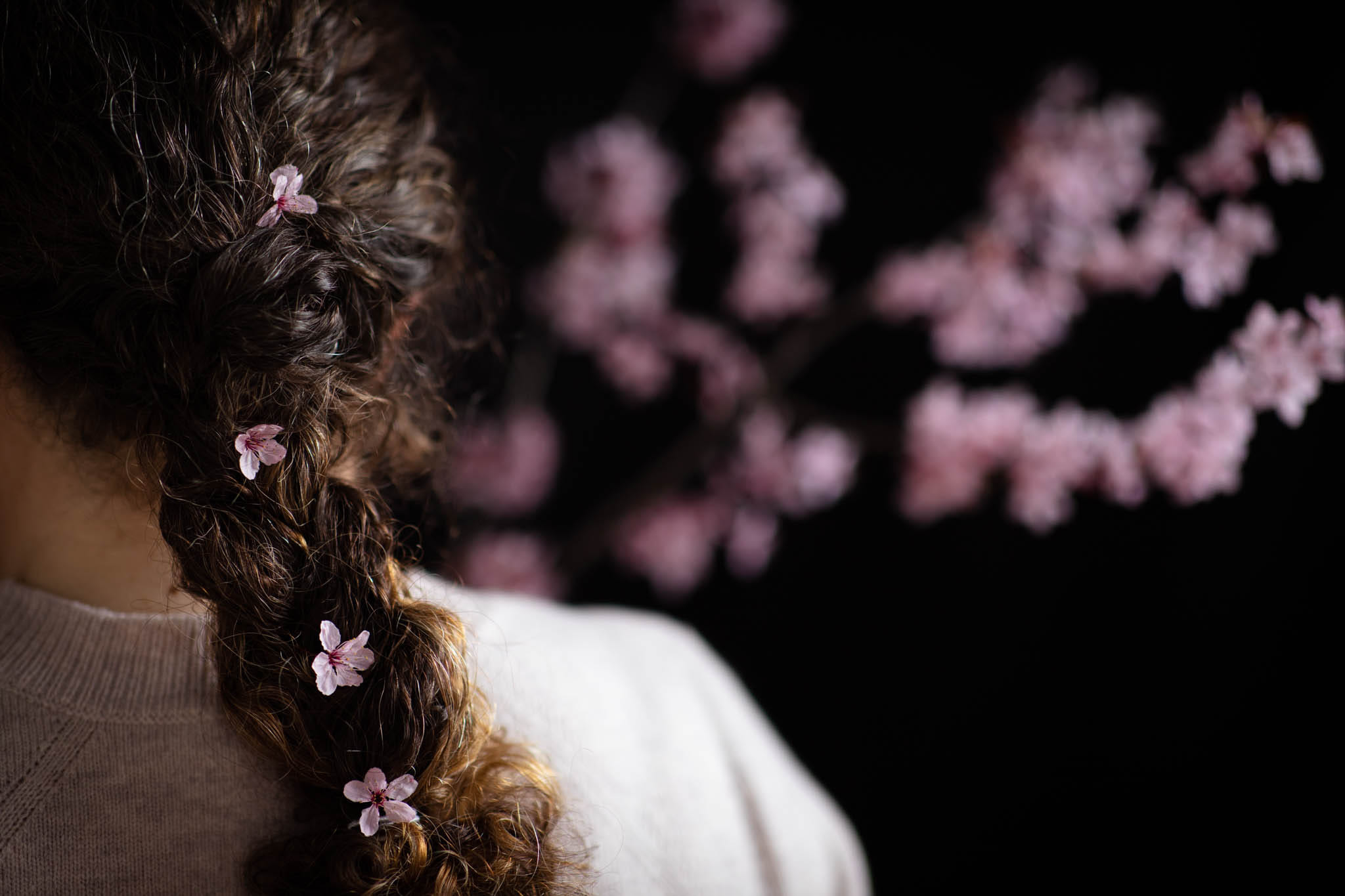 faceless portrait of a woman with blossom braided into her hair