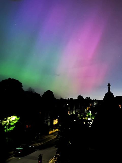 Photo of aurora seen above a town street