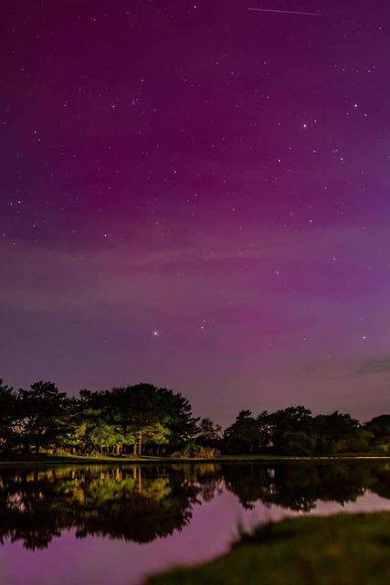 Pink Aurora sky reflected in a lake