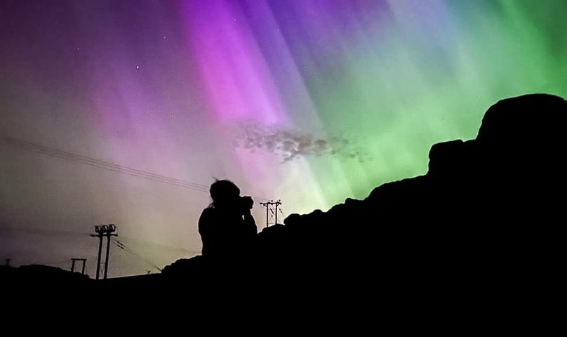 Photo of a photographer capturing aurora