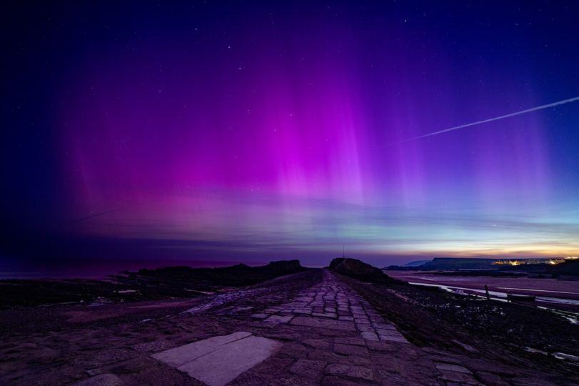 Aurora borealise seen above a stone pier